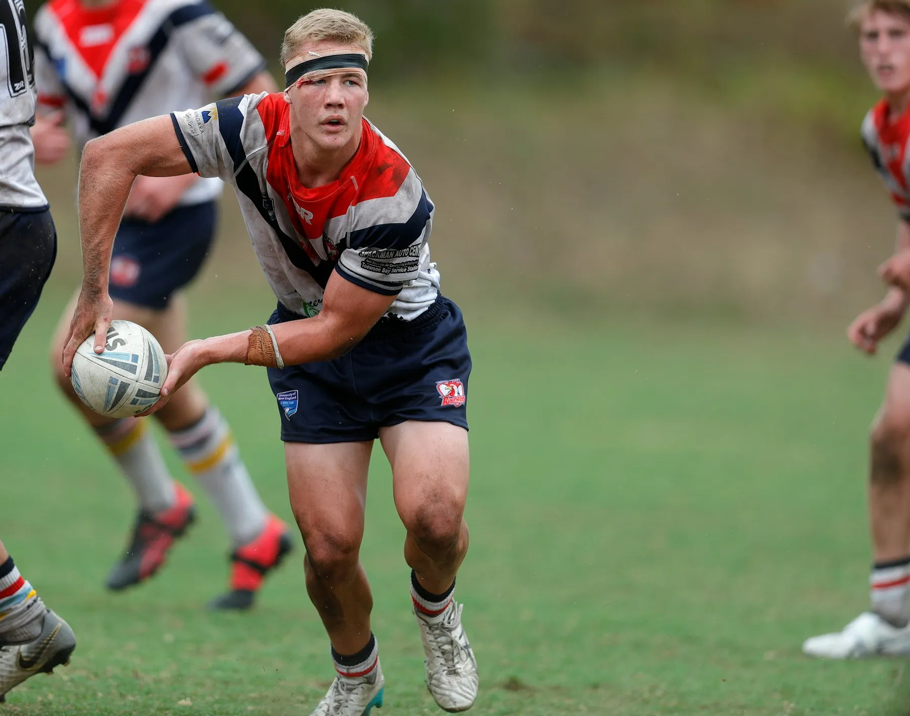 A young rugby league player running with the ball